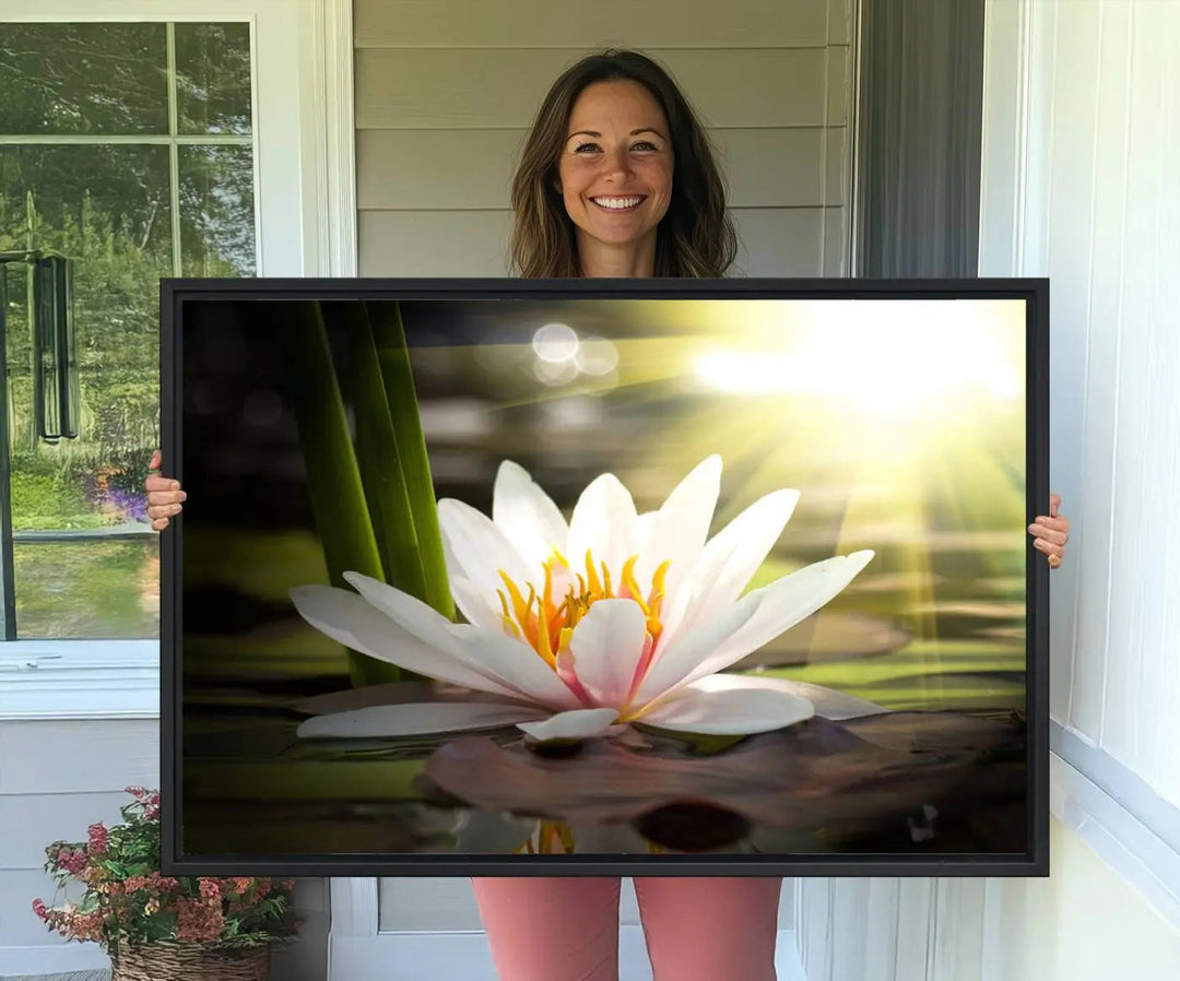 A serene Lotus Flower Wall Art Canvas Print depicts a water lily with sun rays, beautifully displayed on a light-colored wall.