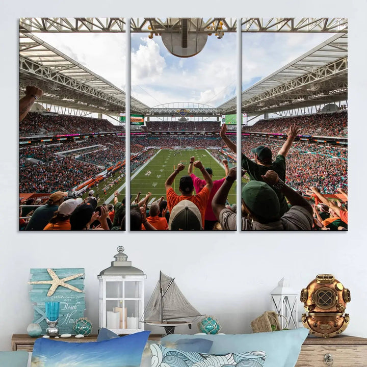 The living room features handmade triptych wall art crafted in the USA, depicting a cheering crowd at a Miami Hurricanes football game. The artwork showcases the Miami Hard Rock Stadium on premium canvas.