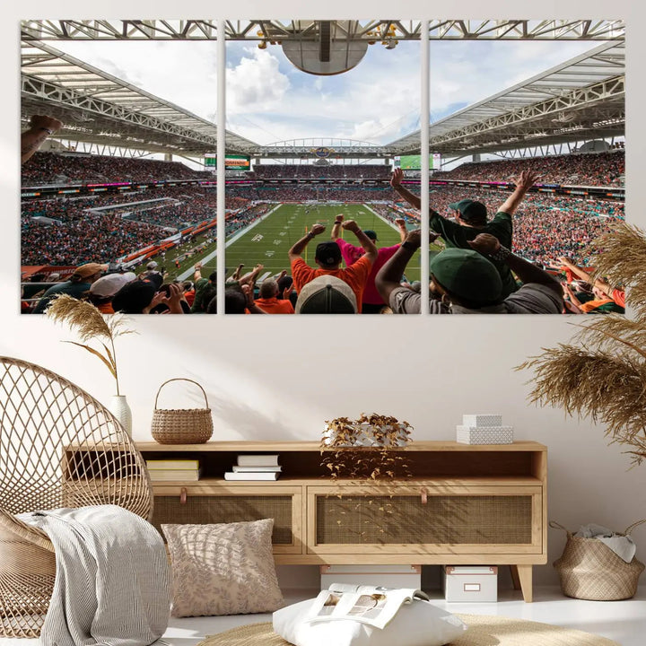 The living room features handmade triptych wall art crafted in the USA, depicting a cheering crowd at a Miami Hurricanes football game. The artwork showcases the Miami Hard Rock Stadium on premium canvas.