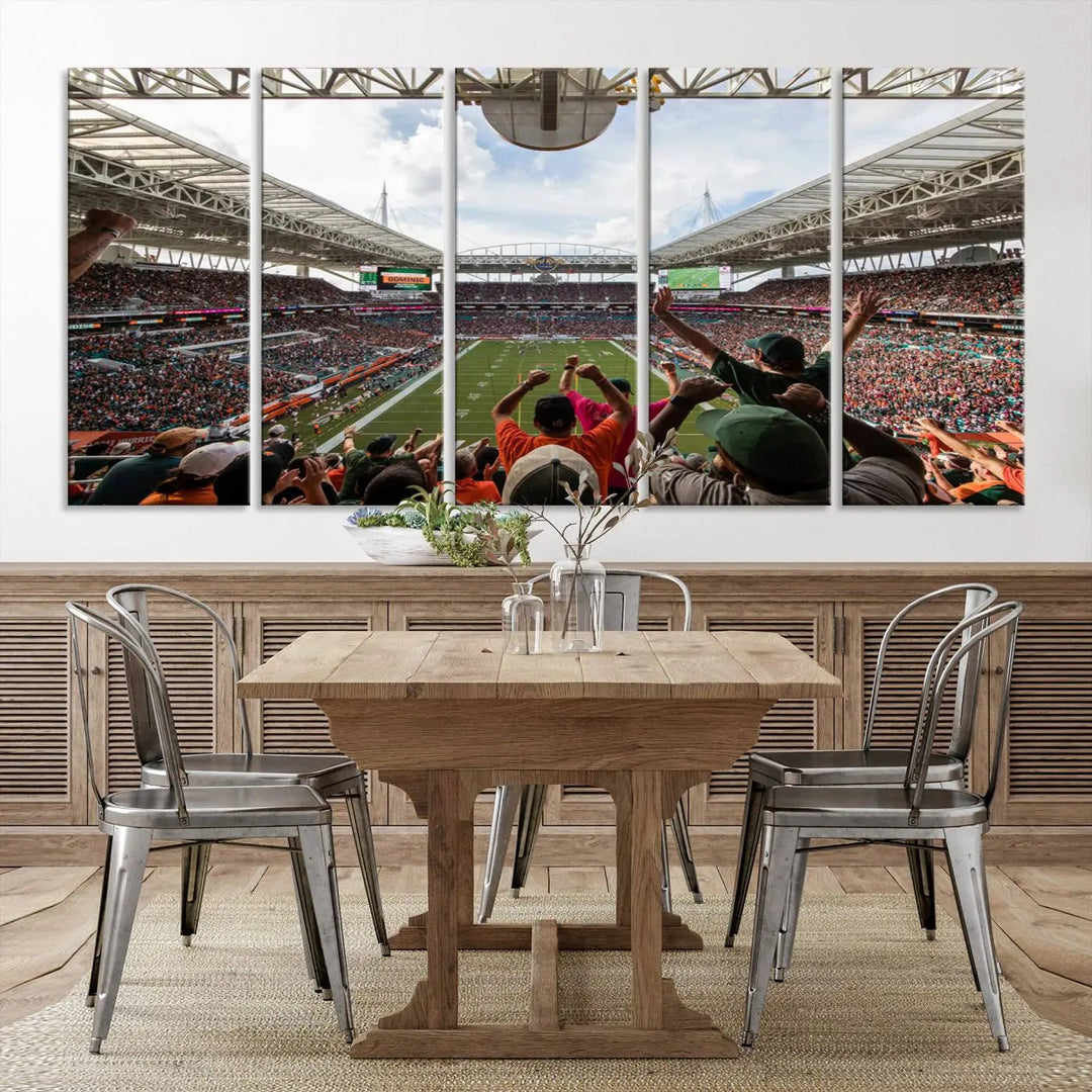 The living room features handmade triptych wall art crafted in the USA, depicting a cheering crowd at a Miami Hurricanes football game. The artwork showcases the Miami Hard Rock Stadium on premium canvas.