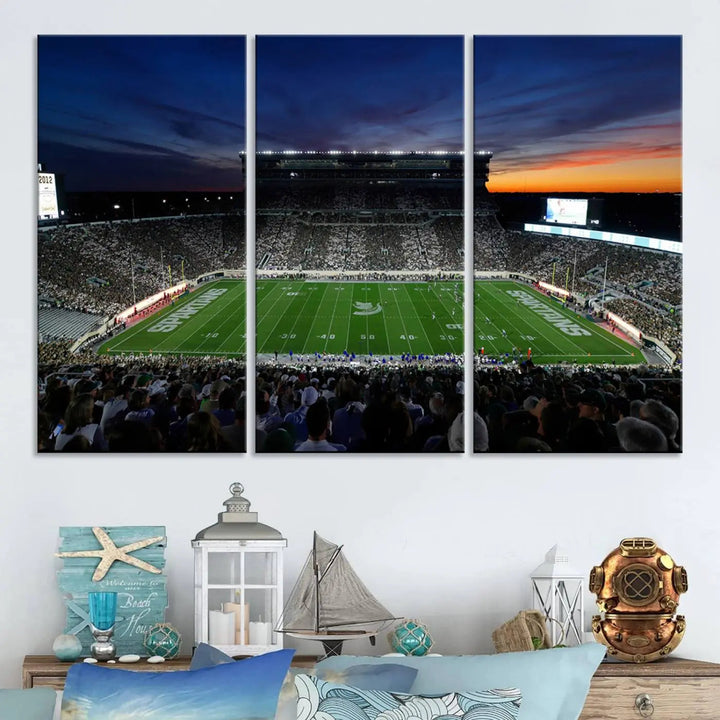 The room showcases a triptych wall art featuring the Michigan State Spartans football team at East Lansing Spartan Stadium at dusk, elegantly printed on premium canvas for a gallery-quality finish.