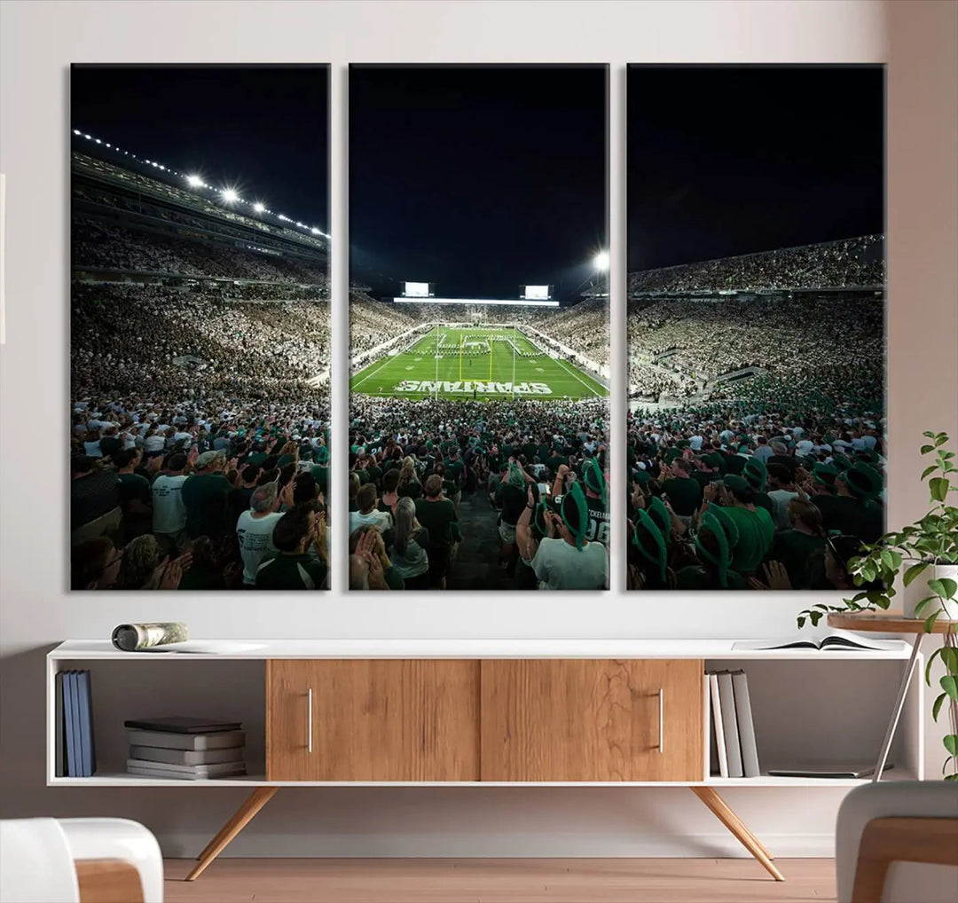 The Michigan State Spartans Football Team Print features an impressive depiction of East Lansing's Spartan Stadium at night, packed with enthusiastic fans. This captivating wall art boasts a gallery-quality finish that enchants any viewer.