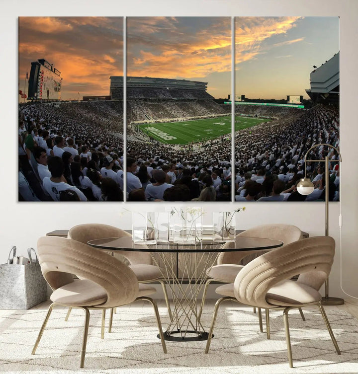 A living room showcasing a stunning Michigan State Spartans Football Team Print on a three-panel canvas, depicting the bustling Spartan Stadium in East Lansing at sunset, all handmade in the USA.