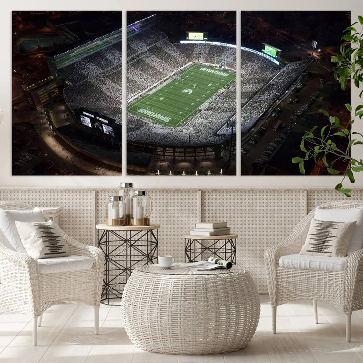 The "Michigan State Spartans Football Team Print - East Lansing Spartan Stadium Wall Art Canvas Print" is elegantly displayed on a wall, showcasing a brightly lit football stadium at night with a gallery-quality finish.