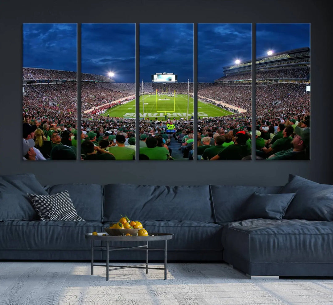 The living room features a Michigan State Spartans Football Team Print, showcasing East Lansing's Spartan Stadium as a triptych wall art above the sofa.