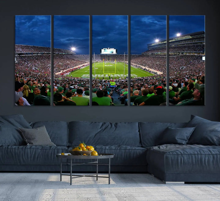 The living room features a Michigan State Spartans Football Team Print, showcasing East Lansing's Spartan Stadium as a triptych wall art above the sofa.