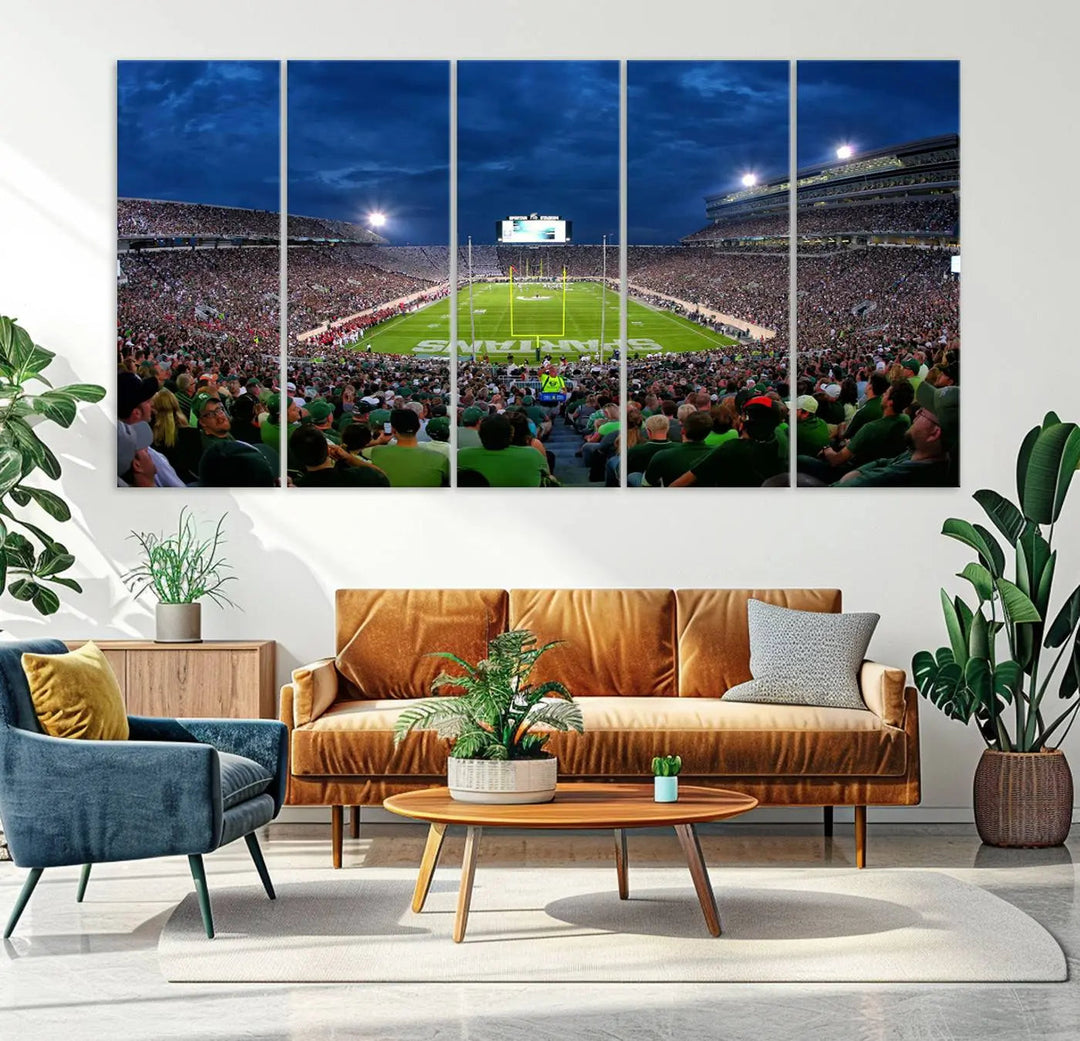 The living room features a Michigan State Spartans Football Team Print, showcasing East Lansing's Spartan Stadium as a triptych wall art above the sofa.