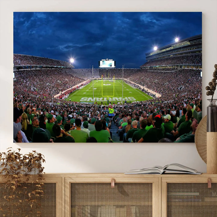 The living room features a Michigan State Spartans Football Team Print, showcasing East Lansing's Spartan Stadium as a triptych wall art above the sofa.