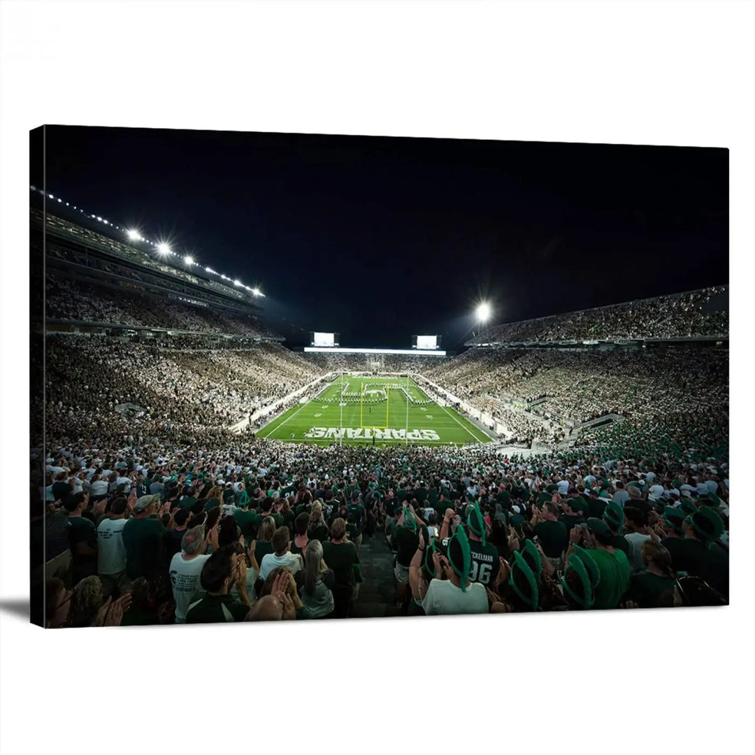 The Michigan State Spartans Football Team Print features an impressive depiction of East Lansing's Spartan Stadium at night, packed with enthusiastic fans. This captivating wall art boasts a gallery-quality finish that enchants any viewer.