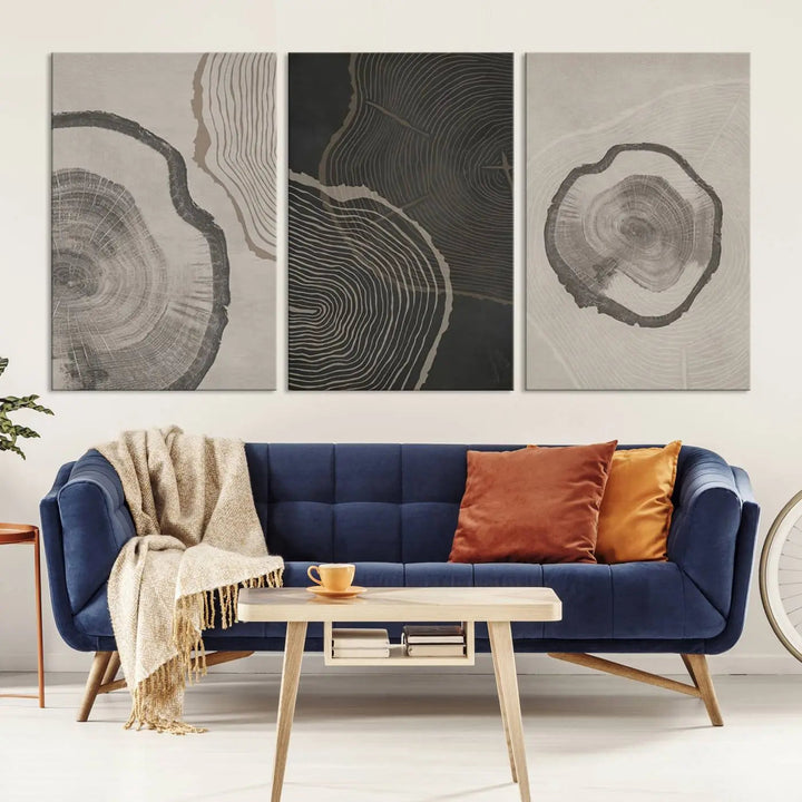 A remarkable set of "Modern Abstract Tree Ring Canvas Art" featuring three panels with large tree ring designs hangs prominently, adding to the minimalistic elegance of the living room.