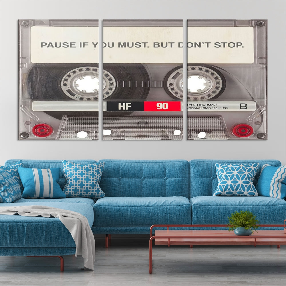 The Music Cassette Iconic Wall Art Canvas Print features a cassette tape with the inspiring message "Pause if you must. But don't stop." It is elegantly printed on museum-quality canvas with a UV-protective coating to ensure long-lasting vibrancy. This gallery-wrapped piece is perfect for any modern space.