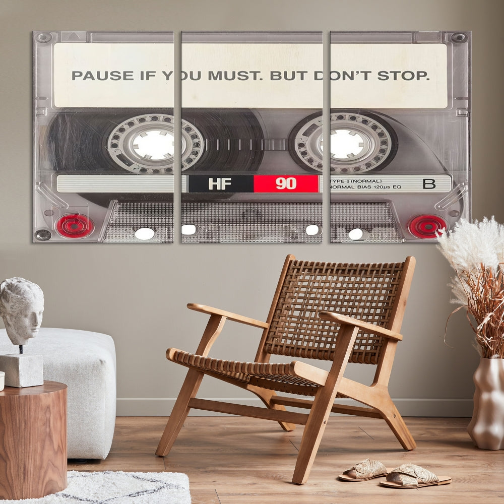 The Music Cassette Iconic Wall Art Canvas Print features a cassette tape with the inspiring message "Pause if you must. But don't stop." It is elegantly printed on museum-quality canvas with a UV-protective coating to ensure long-lasting vibrancy. This gallery-wrapped piece is perfect for any modern space.