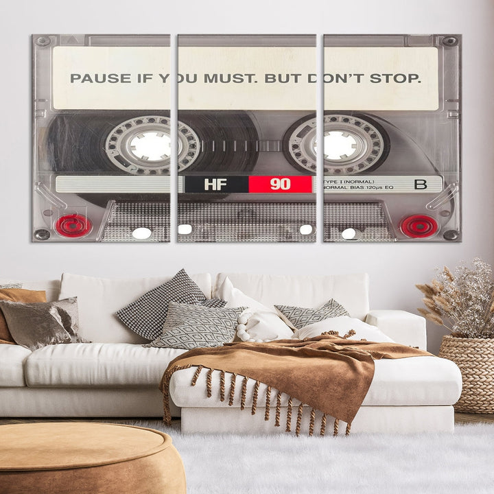 The Music Cassette Iconic Wall Art Canvas Print features a cassette tape with the inspiring message "Pause if you must. But don't stop." It is elegantly printed on museum-quality canvas with a UV-protective coating to ensure long-lasting vibrancy. This gallery-wrapped piece is perfect for any modern space.