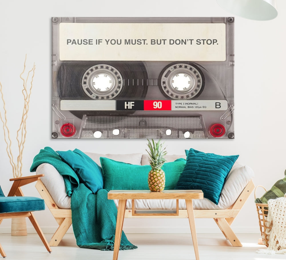 The Music Cassette Iconic Wall Art Canvas Print features a cassette tape with the inspiring message "Pause if you must. But don't stop." It is elegantly printed on museum-quality canvas with a UV-protective coating to ensure long-lasting vibrancy. This gallery-wrapped piece is perfect for any modern space.