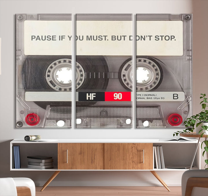 The Music Cassette Iconic Wall Art Canvas Print features a cassette tape with the inspiring message "Pause if you must. But don't stop." It is elegantly printed on museum-quality canvas with a UV-protective coating to ensure long-lasting vibrancy. This gallery-wrapped piece is perfect for any modern space.