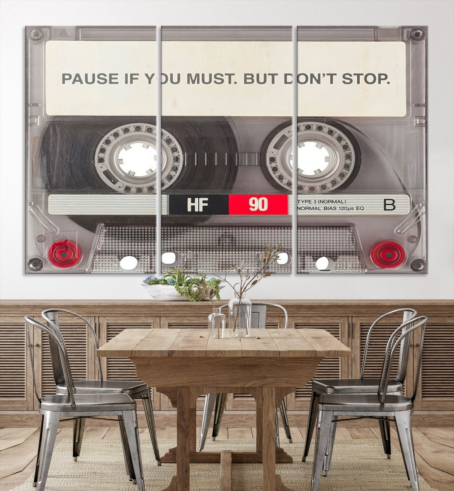 The Music Cassette Iconic Wall Art Canvas Print features a cassette tape with the inspiring message "Pause if you must. But don't stop." It is elegantly printed on museum-quality canvas with a UV-protective coating to ensure long-lasting vibrancy. This gallery-wrapped piece is perfect for any modern space.