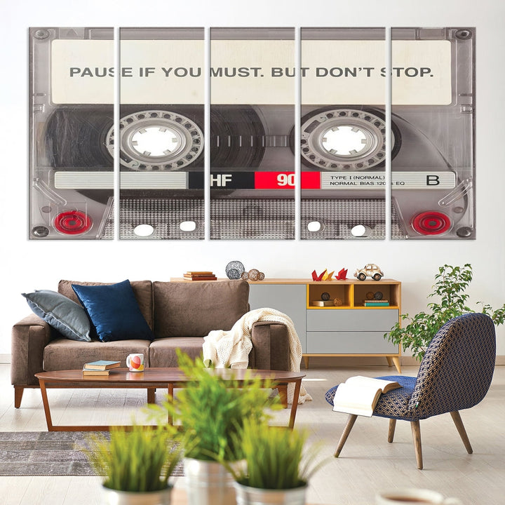 The Music Cassette Iconic Wall Art Canvas Print features a cassette tape with the inspiring message "Pause if you must. But don't stop." It is elegantly printed on museum-quality canvas with a UV-protective coating to ensure long-lasting vibrancy. This gallery-wrapped piece is perfect for any modern space.