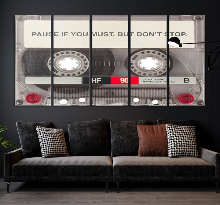 The Music Cassette Iconic Wall Art Canvas Print features a cassette tape with the inspiring message "Pause if you must. But don't stop." It is elegantly printed on museum-quality canvas with a UV-protective coating to ensure long-lasting vibrancy. This gallery-wrapped piece is perfect for any modern space.