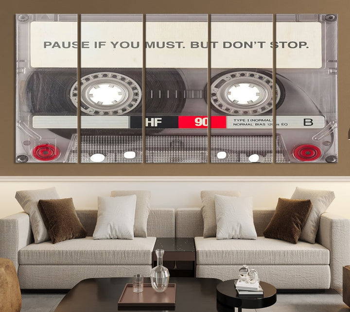 The Music Cassette Iconic Wall Art Canvas Print features a cassette tape with the inspiring message "Pause if you must. But don't stop." It is elegantly printed on museum-quality canvas with a UV-protective coating to ensure long-lasting vibrancy. This gallery-wrapped piece is perfect for any modern space.