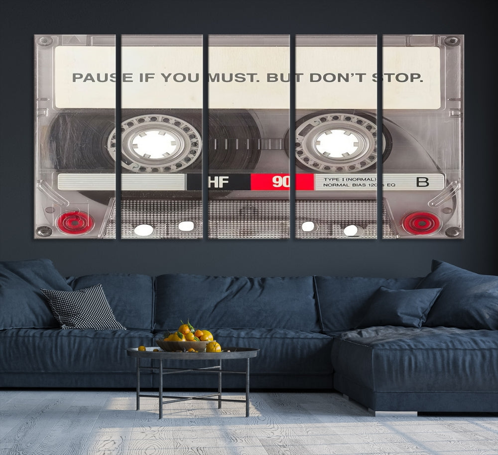 The Music Cassette Iconic Wall Art Canvas Print features a cassette tape with the inspiring message "Pause if you must. But don't stop." It is elegantly printed on museum-quality canvas with a UV-protective coating to ensure long-lasting vibrancy. This gallery-wrapped piece is perfect for any modern space.