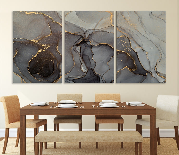 The Gray Marble Fluid Effect Wall Art Abstract Canvas Wall Art Print is a museum-quality canvas featuring triptych abstract art with swirling gray and gold patterns. Complete with a UV-protective coating, this piece of artwork arrives ready to hang, effortlessly elevating your living space.