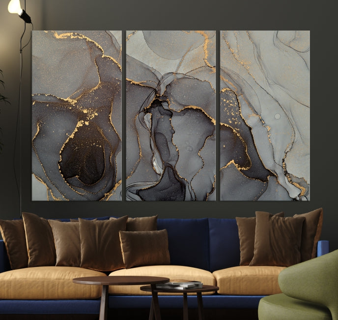 The Gray Marble Fluid Effect Wall Art Abstract Canvas Wall Art Print is a museum-quality canvas featuring triptych abstract art with swirling gray and gold patterns. Complete with a UV-protective coating, this piece of artwork arrives ready to hang, effortlessly elevating your living space.