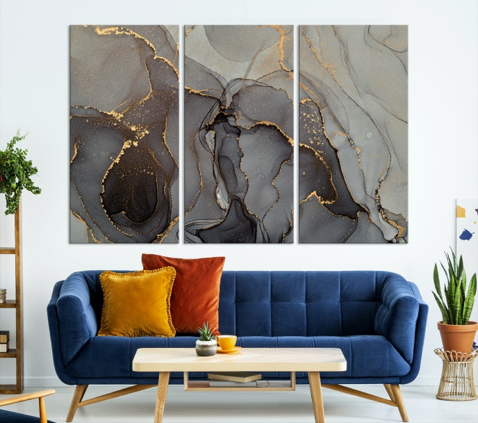 The Gray Marble Fluid Effect Wall Art Abstract Canvas Wall Art Print is a museum-quality canvas featuring triptych abstract art with swirling gray and gold patterns. Complete with a UV-protective coating, this piece of artwork arrives ready to hang, effortlessly elevating your living space.