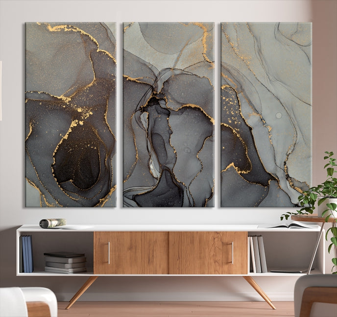 The Gray Marble Fluid Effect Wall Art Abstract Canvas Wall Art Print is a museum-quality canvas featuring triptych abstract art with swirling gray and gold patterns. Complete with a UV-protective coating, this piece of artwork arrives ready to hang, effortlessly elevating your living space.