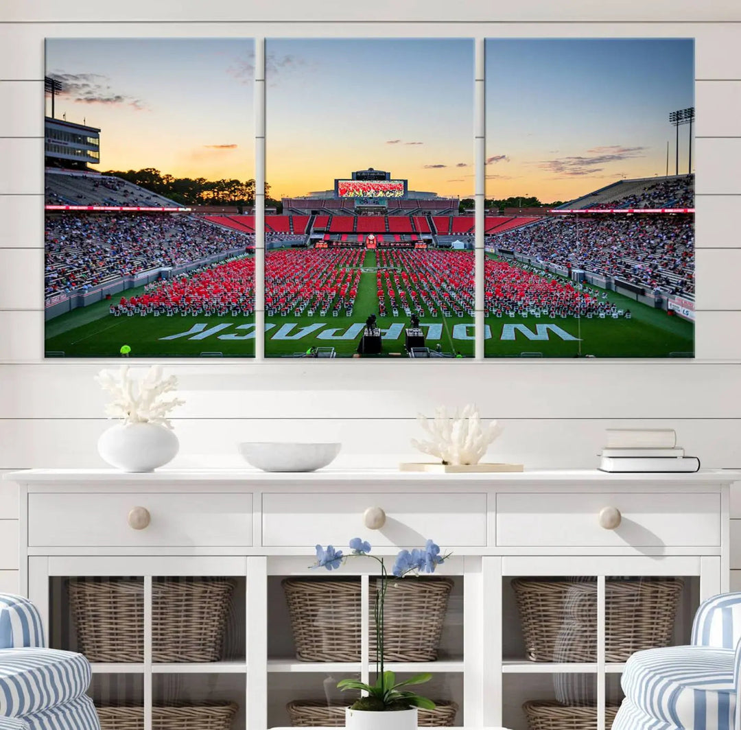 The wall art in the living room features the NC State Wolfpack Football Team Print, beautifully depicting Raleigh's Carter-Finley Stadium at sunset with a crowd dressed in red uniforms. Its gallery-quality finish on premium canvas transforms the scene into captivating artwork.