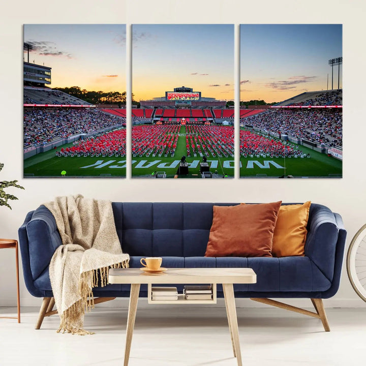 The wall art in the living room features the NC State Wolfpack Football Team Print, beautifully depicting Raleigh's Carter-Finley Stadium at sunset with a crowd dressed in red uniforms. Its gallery-quality finish on premium canvas transforms the scene into captivating artwork.