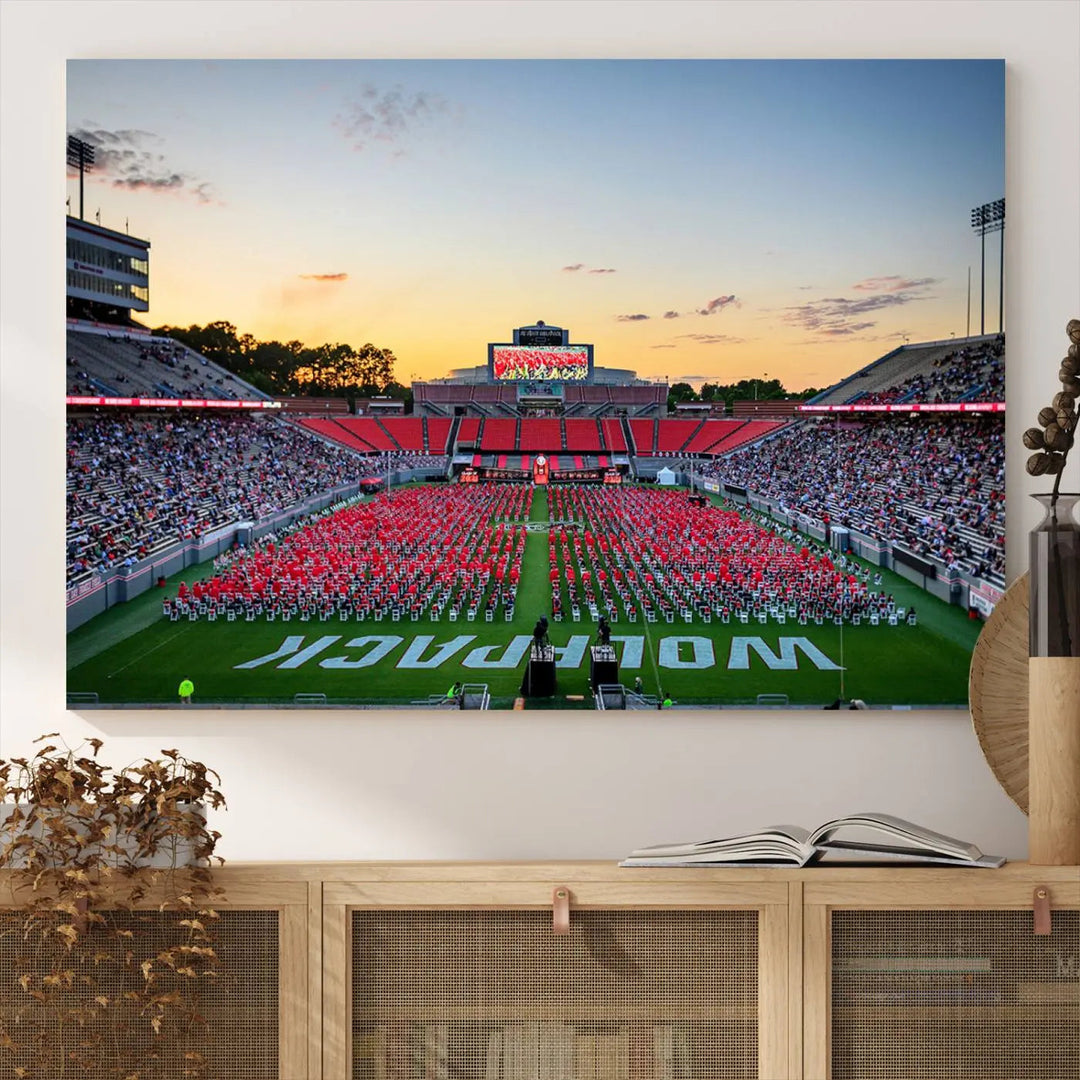 The wall art in the living room features the NC State Wolfpack Football Team Print, beautifully depicting Raleigh's Carter-Finley Stadium at sunset with a crowd dressed in red uniforms. Its gallery-quality finish on premium canvas transforms the scene into captivating artwork.