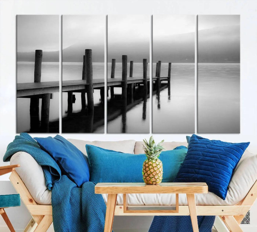 The "Ocean Beach Canvas Wall Art" is a black-and-white triptych depicting a serene dock over water.