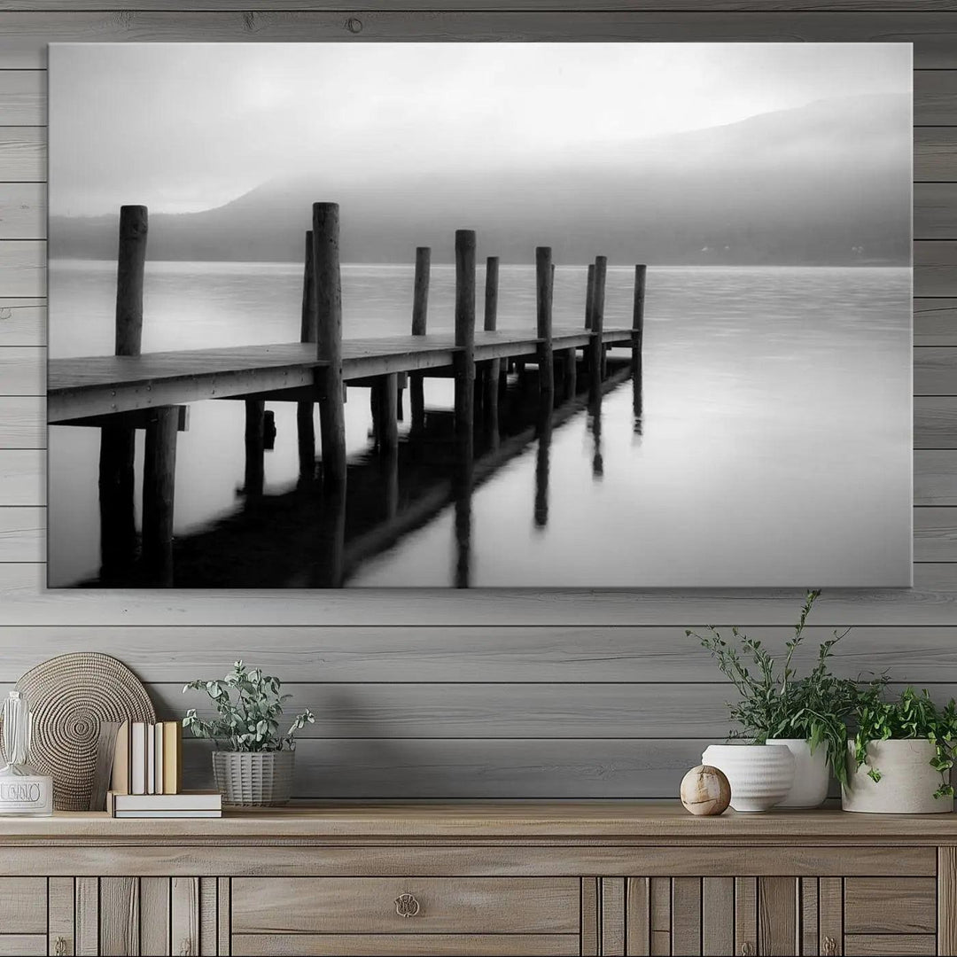 The "Ocean Beach Canvas Wall Art" is a black-and-white triptych depicting a serene dock over water.