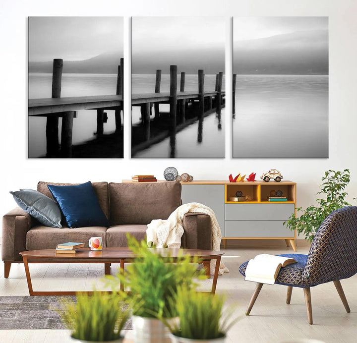 The "Ocean Beach Canvas Wall Art" is a black-and-white triptych depicting a serene dock over water.