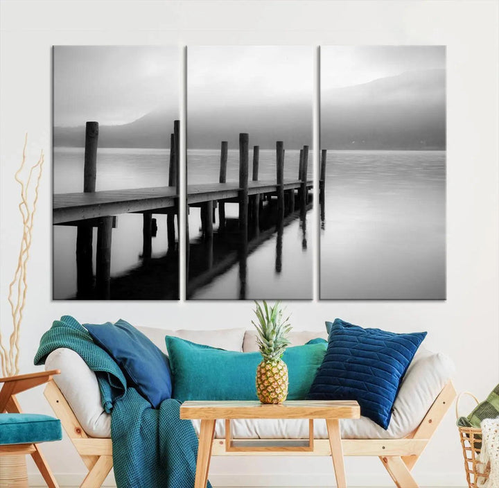 The "Ocean Beach Canvas Wall Art" is a black-and-white triptych depicting a serene dock over water.