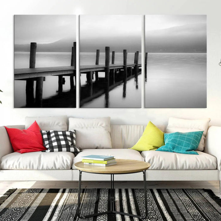 The "Ocean Beach Canvas Wall Art" is a black-and-white triptych depicting a serene dock over water.