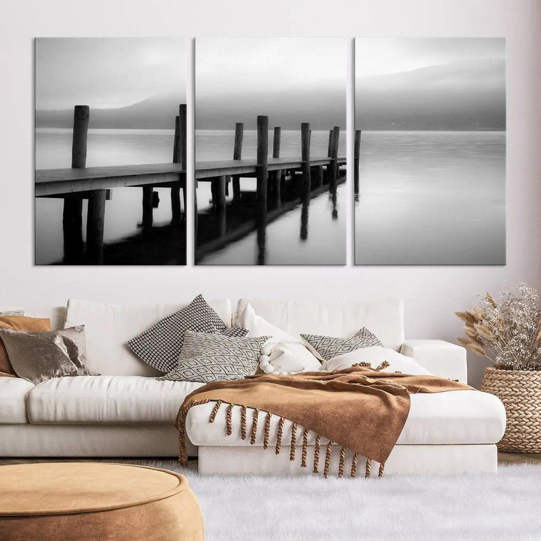 The "Ocean Beach Canvas Wall Art" is a black-and-white triptych depicting a serene dock over water.