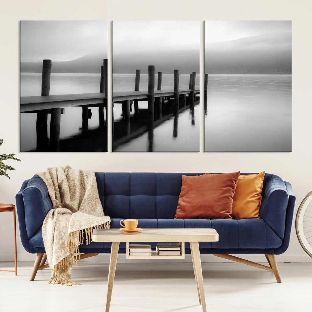 The "Ocean Beach Canvas Wall Art" is a black-and-white triptych depicting a serene dock over water.