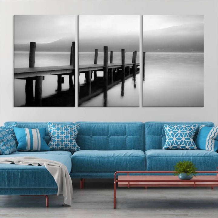 The "Ocean Beach Canvas Wall Art" is a black-and-white triptych depicting a serene dock over water.