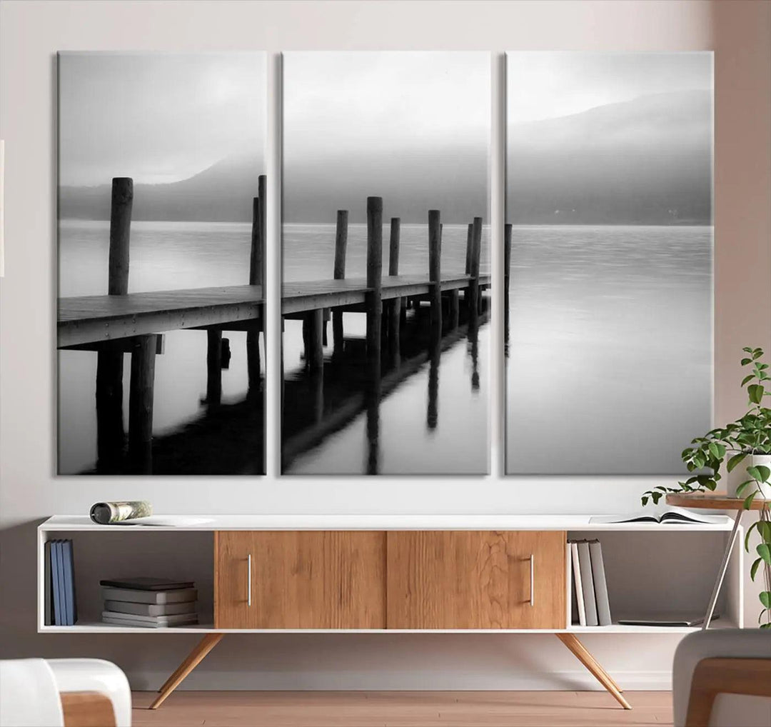 The "Ocean Beach Canvas Wall Art" is a black-and-white triptych depicting a serene dock over water.