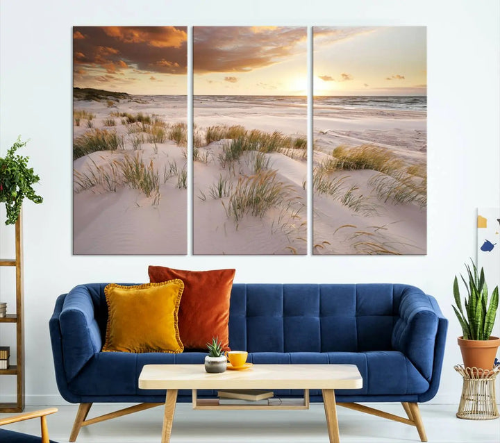 A triptych of the Ocean Beach Wall Art Canvas Print Sunset Artwork Print Coastal Wall Art showcases a serene beach landscape with sand dunes and grasses, gallery wrapped on museum-quality canvas.