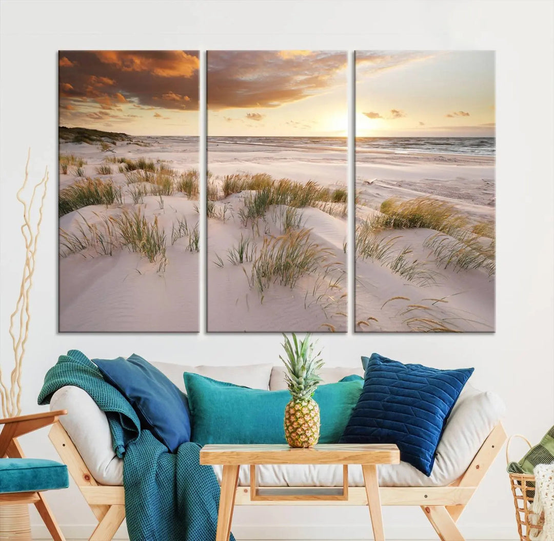 A triptych of the Ocean Beach Wall Art Canvas Print Sunset Artwork Print Coastal Wall Art showcases a serene beach landscape with sand dunes and grasses, gallery wrapped on museum-quality canvas.