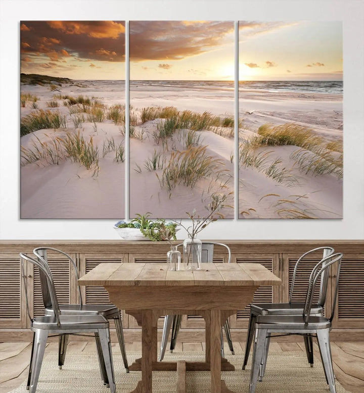 A triptych of the Ocean Beach Wall Art Canvas Print Sunset Artwork Print Coastal Wall Art showcases a serene beach landscape with sand dunes and grasses, gallery wrapped on museum-quality canvas.