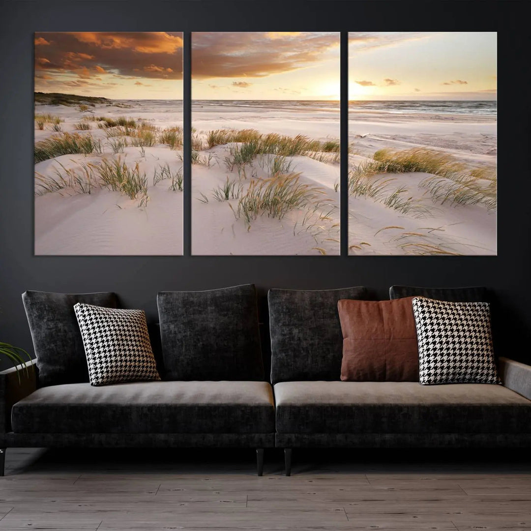 A triptych of the Ocean Beach Wall Art Canvas Print Sunset Artwork Print Coastal Wall Art showcases a serene beach landscape with sand dunes and grasses, gallery wrapped on museum-quality canvas.