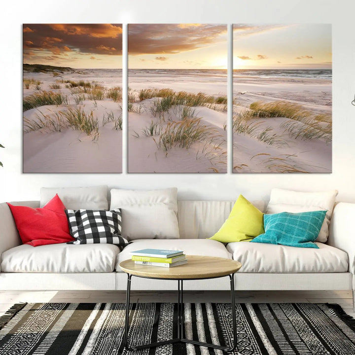 A triptych of the Ocean Beach Wall Art Canvas Print Sunset Artwork Print Coastal Wall Art showcases a serene beach landscape with sand dunes and grasses, gallery wrapped on museum-quality canvas.