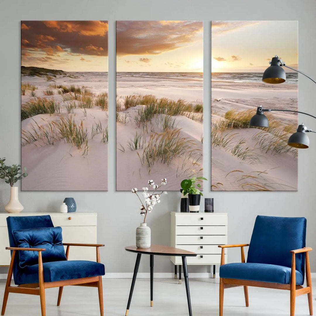 A triptych of the Ocean Beach Wall Art Canvas Print Sunset Artwork Print Coastal Wall Art showcases a serene beach landscape with sand dunes and grasses, gallery wrapped on museum-quality canvas.