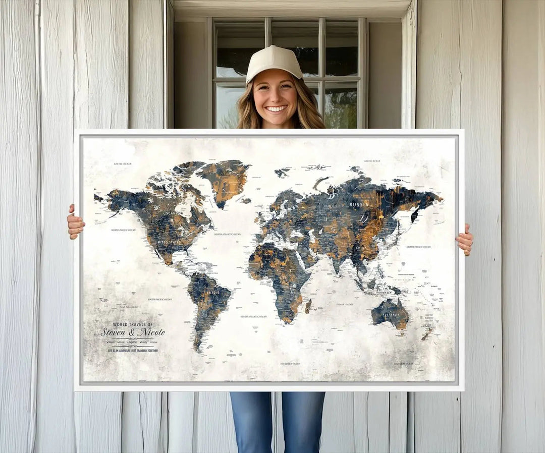 A smiling woman proudly holds the Personalized Push Pin Map Wall Art Print - Detailed Custom World Map Canvas Print in front of a white wall, perfect for travel enthusiasts eager to mark their adventures.