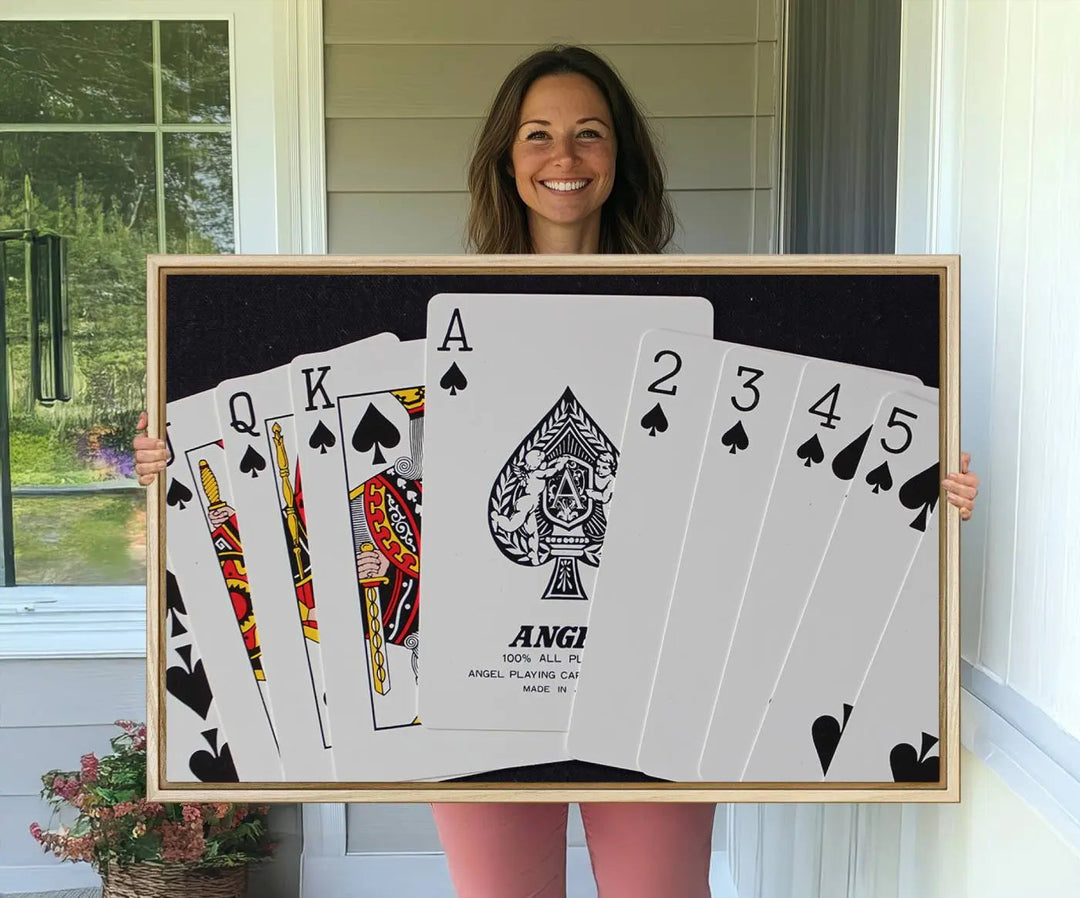 The Poker Wall Art - Playing Cards Canvas Wall Art Print features an Ace of Spades and Royal Flush design. This piece adds a classic charm to any space with its subtle emphasis on the Ace of Spades, making it perfect for game room decor.