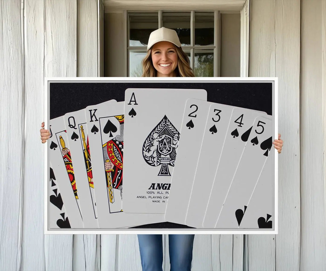 The Poker Wall Art - Playing Cards Canvas Wall Art Print features an Ace of Spades and Royal Flush design. This piece adds a classic charm to any space with its subtle emphasis on the Ace of Spades, making it perfect for game room decor.