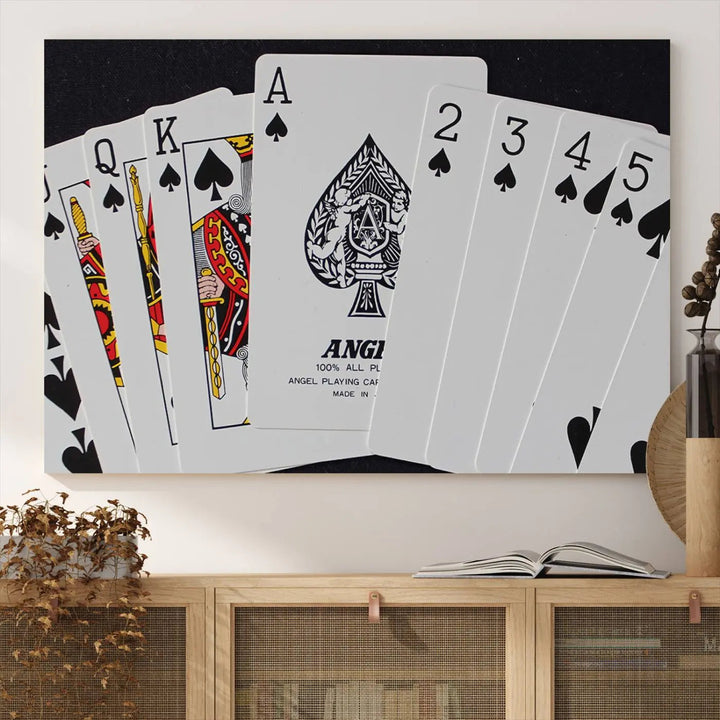 The Poker Wall Art - Playing Cards Canvas Wall Art Print features an Ace of Spades and Royal Flush design. This piece adds a classic charm to any space with its subtle emphasis on the Ace of Spades, making it perfect for game room decor.